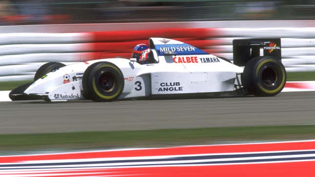 The white, 1994 Tyrrell F1 car being raced in a grand prix. 