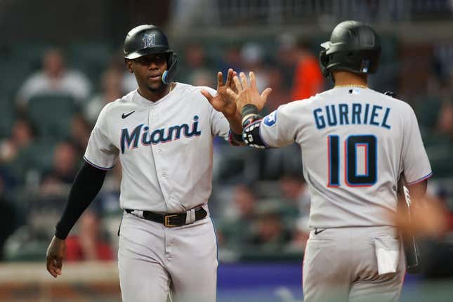 Apr 25, 2023; Atlanta, Georgia, USA; Miami Marlins designated hitter Jorge Soler (12) celebrates after scoring with first baseman Yuli Gurriel (10) against the Atlanta Braves in eighth inning at Truist Park.