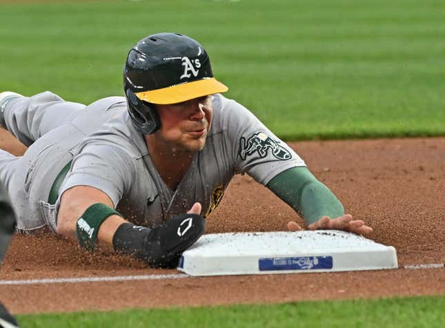 May 5, 2023; Kansas City, Missouri, USA; Oakland Athletics designated hitter Brent Rooker (25) dives into third base after a wild pitch during the first inning against the Kansas City Royals at Kauffman Stadium.