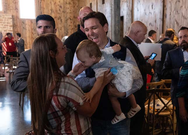 Florida Governor and 2024 Presidential hopeful Ron DeSantis holds a baby during a campaign event at the Sun Valley Barn in Pella, Iowa, on May 31, 2023.