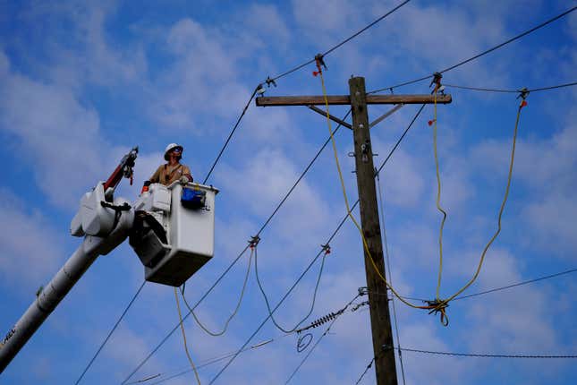 Ryan Brown works on restoring power lines damaged by a tornado two days earlier, Sunday, March 26, 2023, in Rolling Fork, Mississippi. 