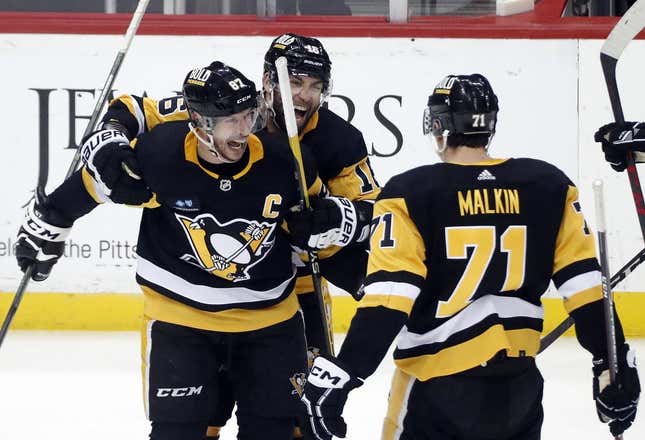 Mar 7, 2023; Pittsburgh, Pennsylvania, USA;  Pittsburgh Penguins center Sidney Crosby (87) reacts with left wing Jason Zucker (16) and center Evgeni Malkin (71) after Crosby scored the game winning power play goal in overtime against the Columbus Blue Jackets at PPG Paints Arena. Pittsburgh won 5-4 in overtime.