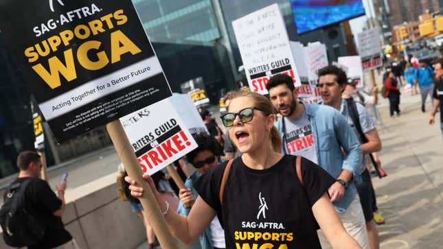 People carry signs on a picket line as part of the WGA strike.