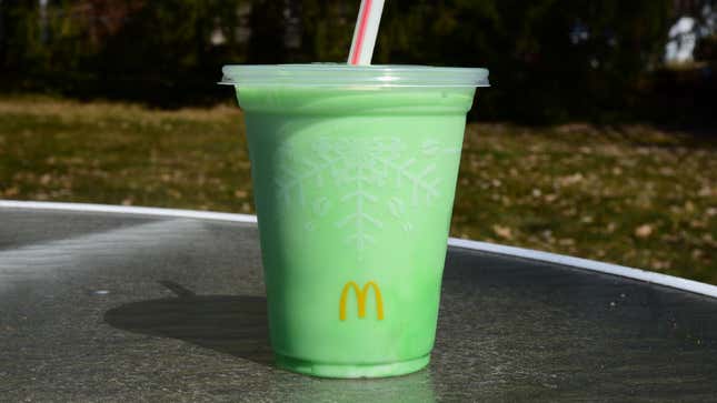 Shamrock Shake from McDonald's sits on a glass table outside. 