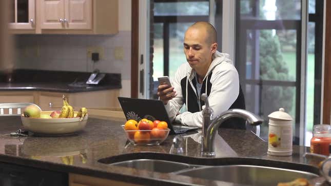 A man using a phone in his smart kitchen.