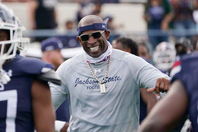 Jackson State football coach Deion Sanders smiles as he greets his defensive squad after they had recovered a Mississippi Valley State fumble for a touchdown during the second half of an NCAA college football game, Sunday, March 14, 2021, in Jackson, Miss. Sanders is trying to win games at Jackson State and raise the profile of historically black colleges and universities around the nation.