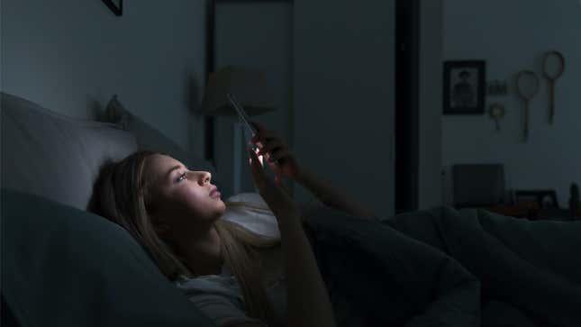 person looking at their phone in bed