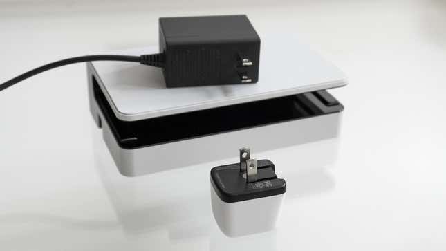The Human Things Genki Covert Dock Mini sitting next to the Nintendo Switch OLED's dock and charger.