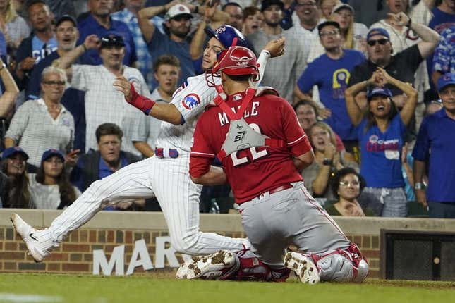 Aug 3, 2023; Chicago, Illinois, USA; Cincinnati Reds catcher Luke Maile (22) tags out Chicago Cubs third baseman Nick Madrigal (1) during the fourth inning at Wrigley Field.