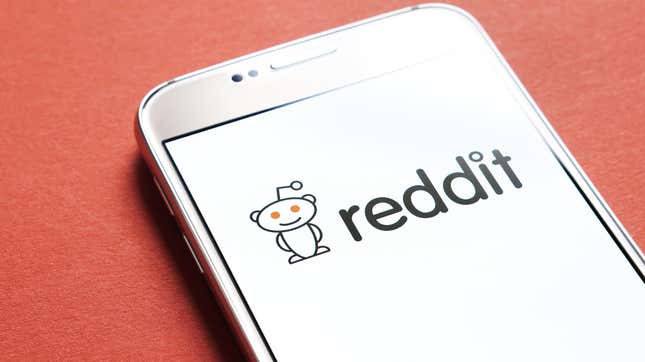 Reddit app open on screen of a smartphone, sitting on red background