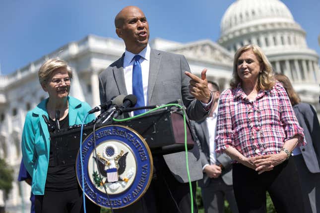 U.S. Sen Cory Booker (D-NJ) (C), joined by Sen. Elizabeth Warren (D-MA) (L) and Rep. Carolyn Maloney (D-NY), speaks at a press conference on bank overdraft fees on July 12, 2022, in Washington, DC