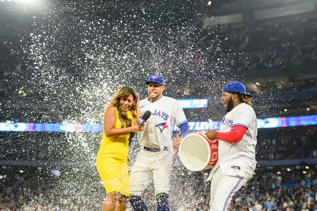 Toronto Blue Jays star Vladimir Guerrero Jr. (r.) douses George Springer (center) and television reporter Hazel Mae (l.) after defeating the Tampa Bay Rays