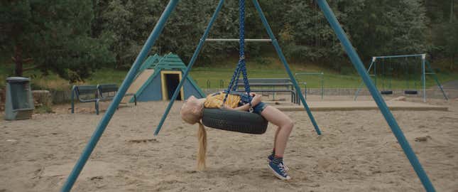 A young girl on a tire swing