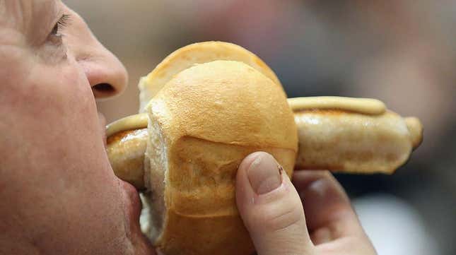 Man eating extremely long bratwurst