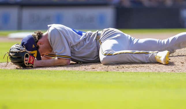 Apr 15, 2023; San Diego, California, USA;  Milwaukee Brewers relief pitcher Gus Varland lies on the ground after being hit by a line out by San Diego Padres third baseman Manny Machado (not pictured) during the eighth inningat Petco Park.