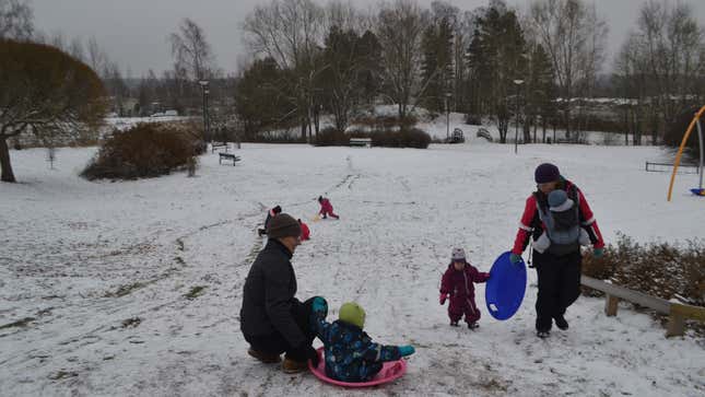Parents play with their children in the snow near the Kotikolo family café