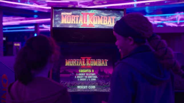Ellie and Riley stand before a Mortal Kombat II machine in HBO's The Last of Us.
