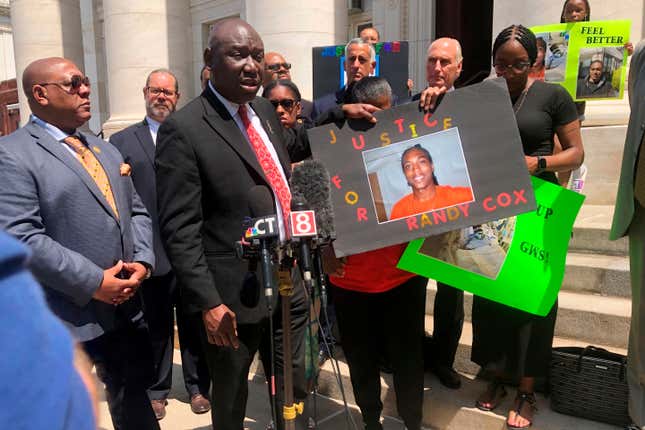 Attorney Benjamin Crump, foreground left, and Doreen Coleman, mother of Randy Cox, hold a poster of Cox, outside a courthouse in New Haven, Conn., Friday, July 8, 2022. Cox, who was being transported in a police van without seatbelts, was paralyzed when the van braked suddenly. His family asked federal authorities Friday to file civil rights charges against the officers involved. 