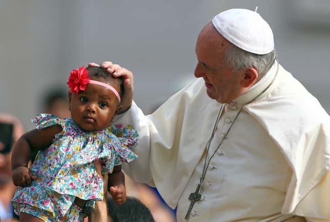Pope Francis blesses a child as he arrives to lead the Wednesday general audience in Saint Peter’s square at the Vatican, on June 13, 2018.
