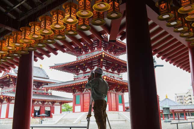 Wearing the technicians’ signature mint-green jacket, employee Dennis Proshchanka inspects Osaka’s 1,000-year-old Shitennoji temple.
