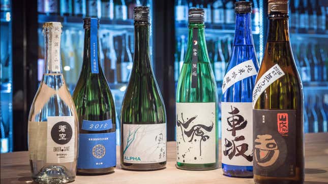 Different sake bottles sit on a table in a restaurant. 