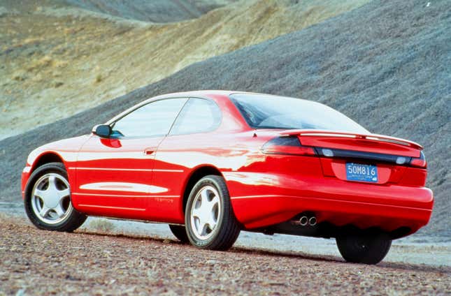 Stellantis'in arka çeyrekten görüntülenen kırmızı 1994 Dodge Avenger'ın basın görüntüsü.