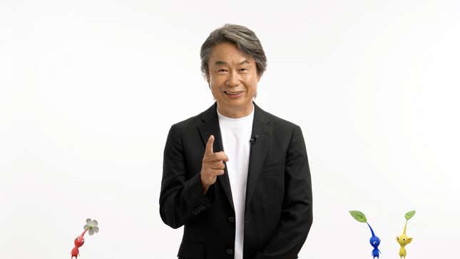 Shigeru Miyamoto gestures toward the screen while surrounded by Pikmin during today's Nintendo Direct.