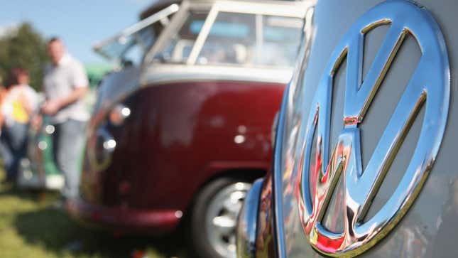 A close up photo of a polished VW badge on the front of an old bus. 
