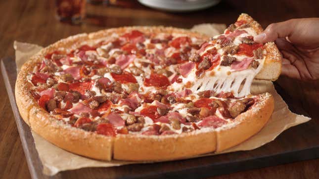 Pizza Hut Meat Lover's Pizza With Slice Being Taken Out