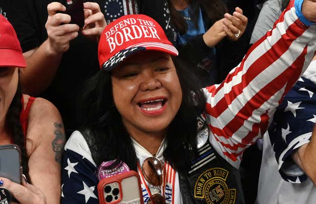 Mimi Israelah, center, cheers for Donald Trump inside the Alaska Airlines Center in Anchorage, Alaska, during a rally Saturday July 9, 2022. An investigation has been launched after a person believed to be an Anchorage, Alaska, police officer was shown in a photo with Israelah flashing a novelty “White Privilege card.” The social media post caused concerns about racial equality in Alaska’s largest city. 