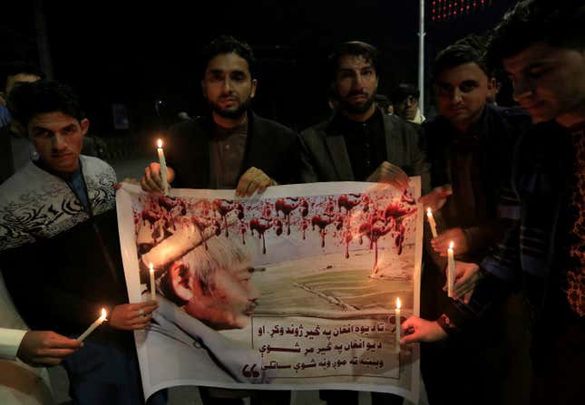 Men light candles in front of the portrait of Japanese doctor Tetsu Nakamura, who was killed in today’s attack in Jalalabad, Afghanistan December 4, 2019.REUTERS/Parwiz – RC2EOD9ZKJXQ