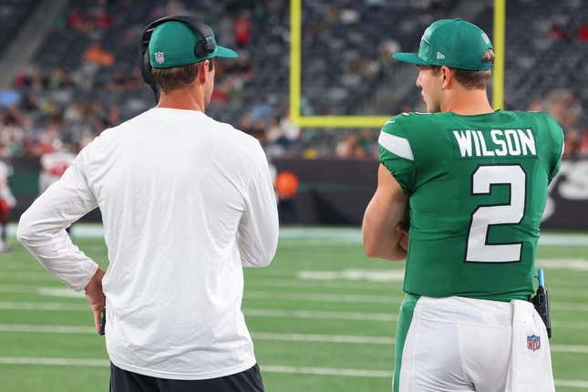 New York Jets quarterbacks Aaron Rodgers (8) and Zach Wilson (2) talk during the second half of their game against the Tampa Bay Buccaneers at MetLife Stadium.