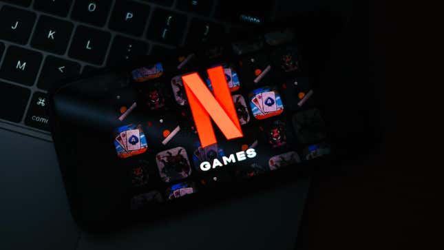 The Netflix Games logo on a phone sitting on top of a laptop's keys.