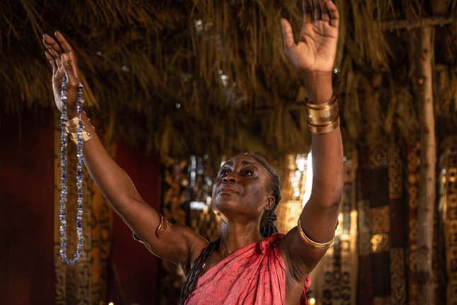 Queen Njinga with her arms raised