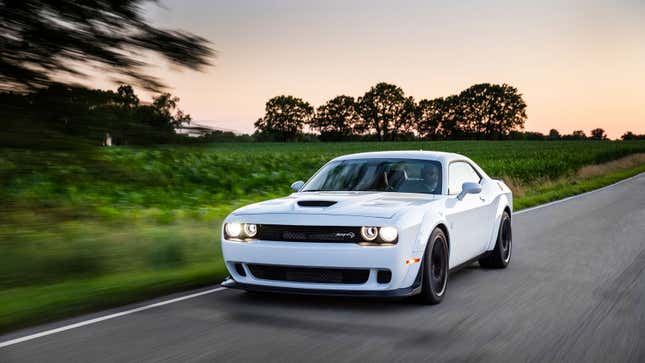 A photo of a white Dodge Challenger Hellcat muscle car. 