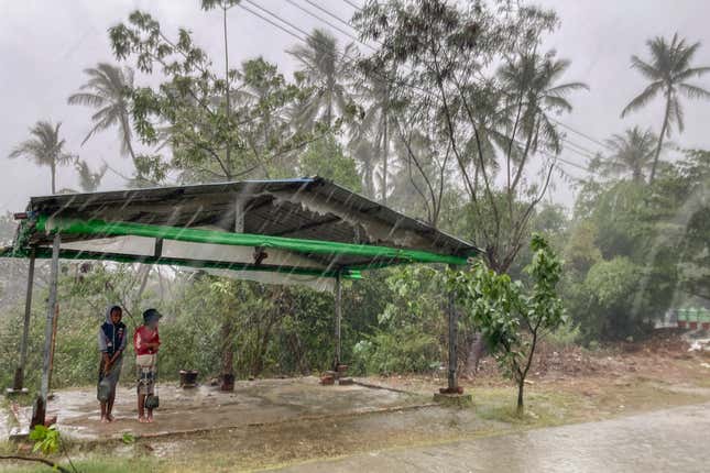 Two children stand under a shelter as Cyclone Mocha begins to make landfall in Sittwe, Rakhine, Myanmar on May 14. 