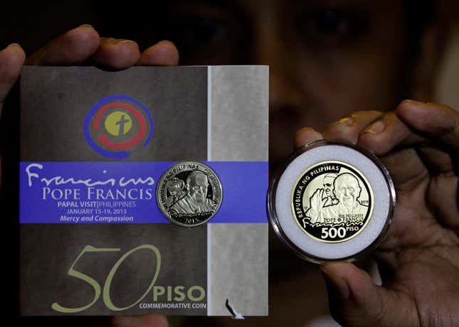 A worker shows commemorative coins with the portrait of Pope Francis during a news conference at the Bangko Sentral ng Pilipinas (Central Bank of the Philippines) in Manila January 14, 2015. The 50-peso ($1.12) commemorative coin for Pope Francis is made of Nickel Brass while the 500-peso ($11.21) is made of Nordic Gold with gold plating. Pope Francis is scheduled to visit the Philippines from January 15-19.