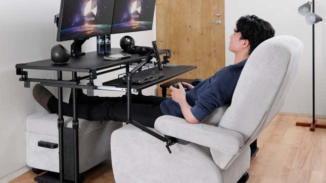 A gamer sitting in the Bauhutte Gaming Sofa Deluxe pulled up to a desk with a pair of computer monitors angled down to face them.