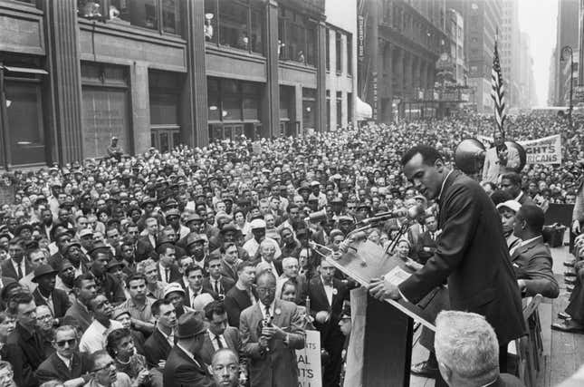 A crowd of over 10,000 civil rights marchers gathers in the Manhattan Garment Center as Harry Belafonte sings at spiritual at a civil rights rally.