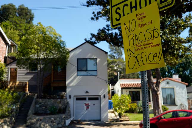 A sign condemning Los Angeles City Council member Kevin de León is posted across the street from his home in Los Angeles, Tuesday, Oct. 18, 2022. The Council has been in upheaval for the past week after an explosive recording was leaked of a private meeting in which then-council president Nury Martinez made crude and racist remarks, and fellow council members De Leon and Gil Cedillo didn’t object or joined in the offensive banter. Martinez has since resigned from the council. 