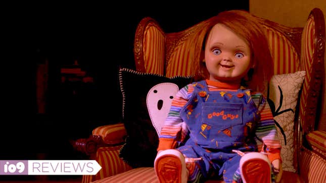 A grinning Chucky doll sits in an armchair