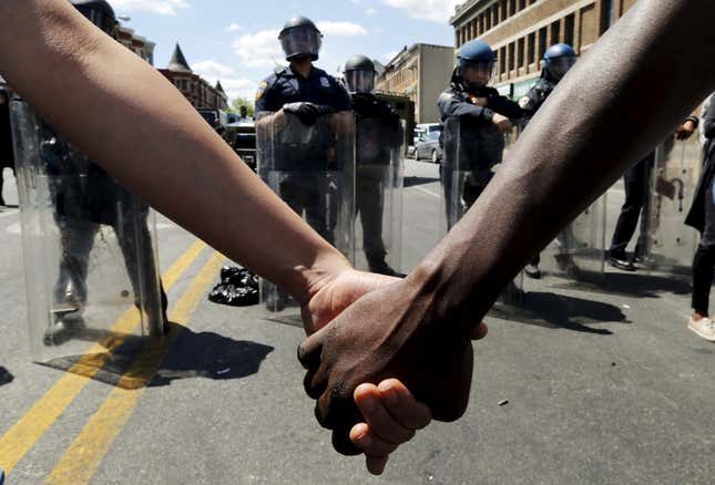 Holding hands in front of a police line in Baltimore. (Reuters//Jim Bourg)