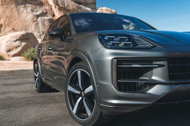 Close-up of the front three-quarters of the 2024 Porsche Cayenne SUV. It's gray.