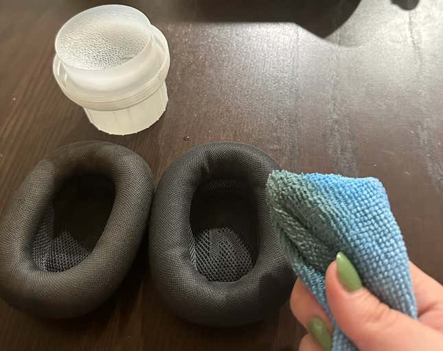 A woman washes her AirPods Max ear cushions.
