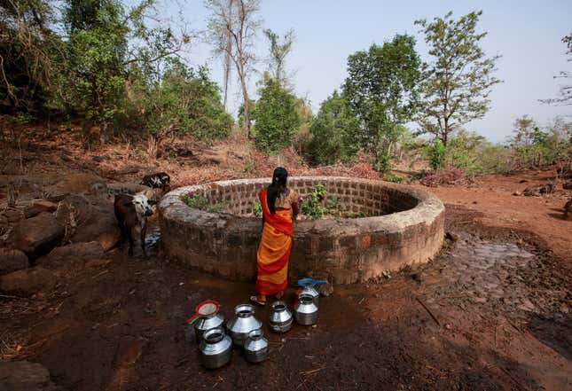 A resident fetches water from a well