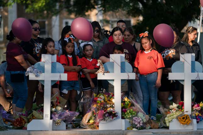 People gather at a memorial site to pay their respects for the victims killed in this week’s elementary school shooting in Uvalde, Texas, Thursday, May 26, 2022.