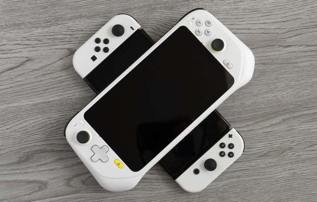 The Logitech G Cloud sitting atop the Nintendo Switch OLED against a gray wooden background.