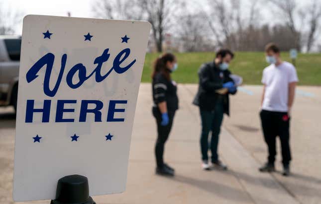  Poll worker Josh Harrison, center, works with Chad Donahue, right, during curbside voting on April 7, 2020, in Madison, Wisconsin. 