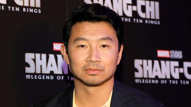 A close-up on Simu Liu on a red carpet with Marvel's Shang-Chi and the Legend of the Ten Rings logos behind him.