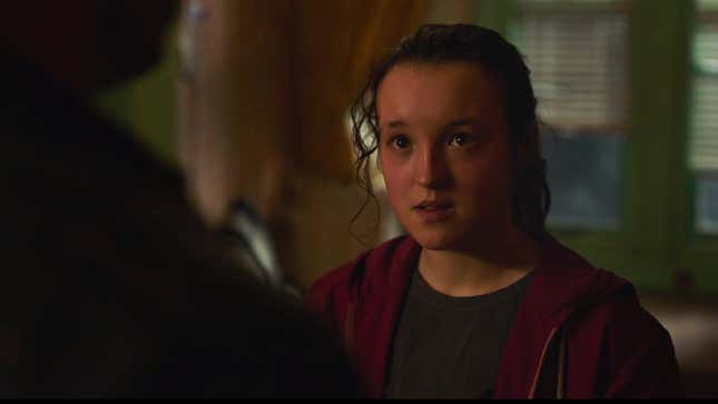 Bella Ramsey as Ellie looks intently at Joel in the foreground in a scene from HBO's The Last of Us.